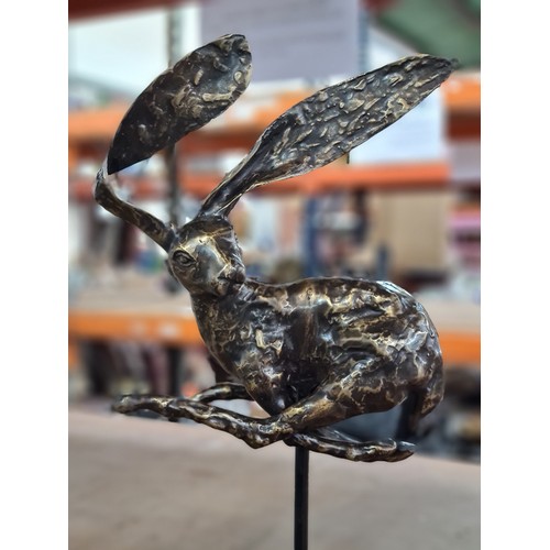 158 - Star Lot : A large intricate bronze sculpture depicting a whimsical hare in mid-leap, showcasing exq... 