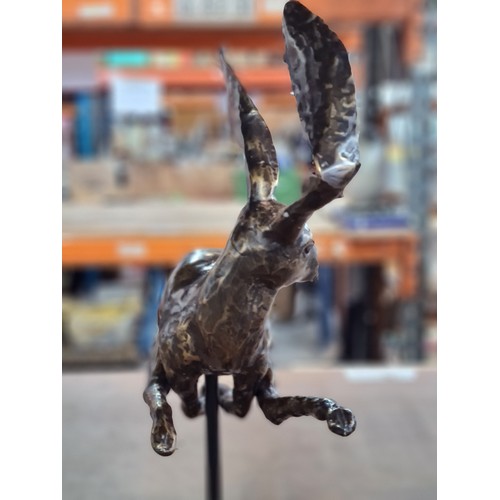 158 - Star Lot : A large intricate bronze sculpture depicting a whimsical hare in mid-leap, showcasing exq... 