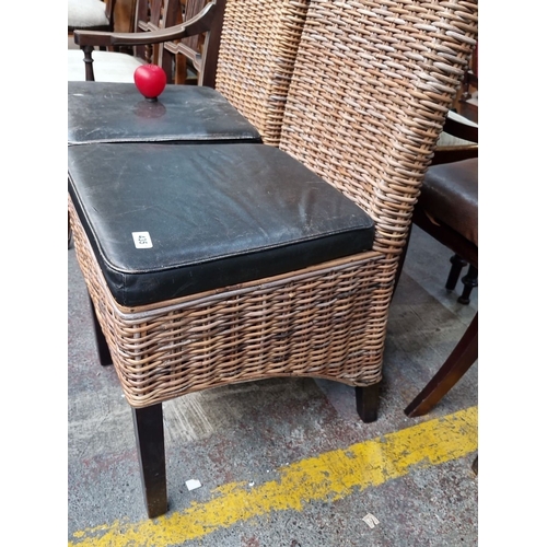 435 - Pair of wicker chairs with high backs and black leather cushions. Dimensions: 100 cm high, 40 cm sea... 