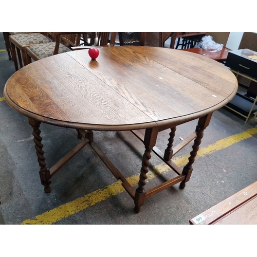 445 - A lovely example of a very early 20th century oak drop-leaf gateleg table,  featuring turned wood ba... 