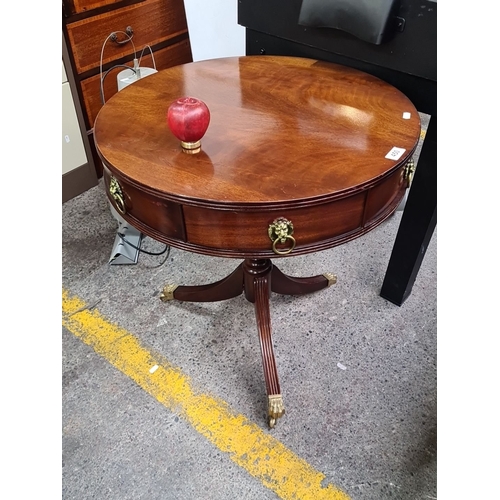 450 - A Mahogany circular Victorian sdrum table with brass lion head drawer pulls and claw feet tripod leg... 