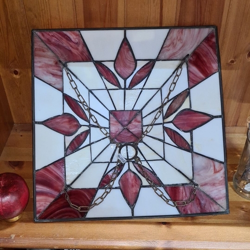 471 - A superb stained glass lampshade featuring a geometric and floral design with red and white panels.