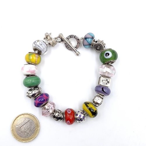 14 - A Sterling Silver Carousel multi charm bracelet by Carousel set with T-bar clasp. Weight - 60.51 gra... 