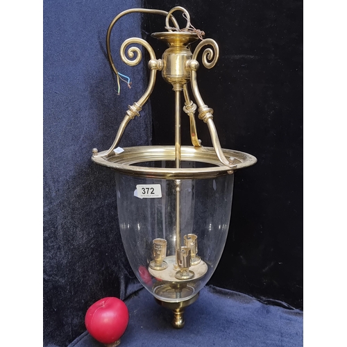 372 - A handsome brushed brass hall lantern with a glass shade and 3 bulb holder, in good order.