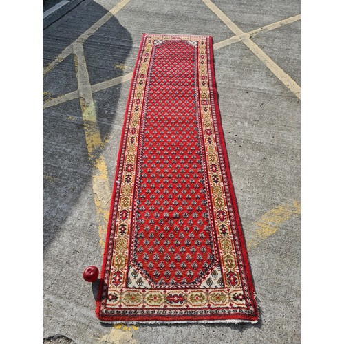 693 - Star Lot: A beautiful long hand knotted, Indian made, runner rug. A vibrant piece, predominantly in ... 