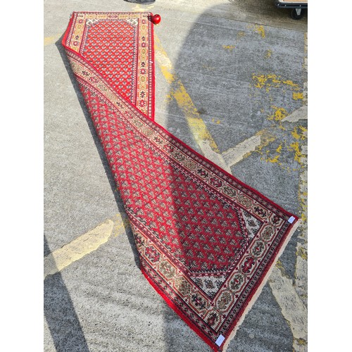 693 - Star Lot: A beautiful long hand knotted, Indian made, runner rug. A vibrant piece, predominantly in ... 