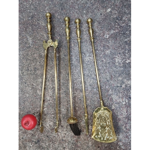 633 - Set of four brass Victorian-style fireplace tools comprising tongs, poker, brush, and shovel. Elegan... 