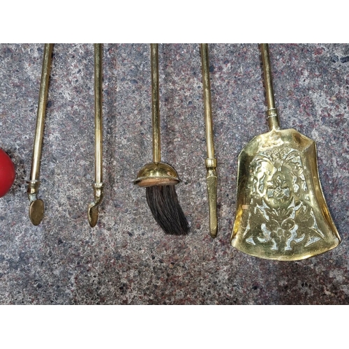 633 - Set of four brass Victorian-style fireplace tools comprising tongs, poker, brush, and shovel. Elegan... 