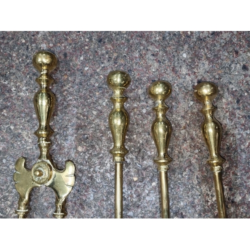 633 - Set of four brass Victorian-style fireplace tools comprising tongs, poker, brush, and shovel. Elegan... 