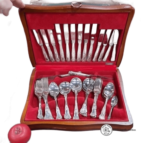 634 - A newbridge Stainless steel cutlery set consisting of knives, forks, and spoons, housed in a red vel... 