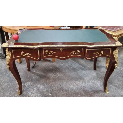 649 - Star Lot : A French Mahogany desk with green leather inlay top, ornate gilt bronze ormolu mounts, an... 