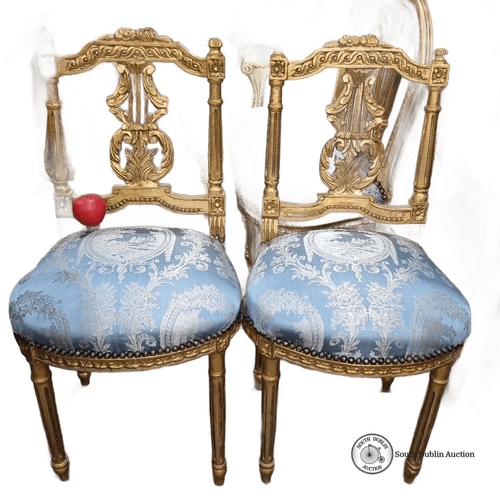 656 - Star Lot : A stunning Pair of Louis XVI-style gilded side chairs with ornate carving. Upholstered in... 