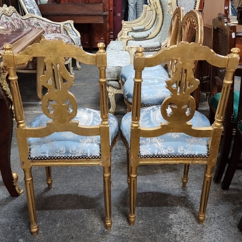 656 - Star Lot : A stunning Pair of Louis XVI-style gilded side chairs with ornate carving. Upholstered in... 