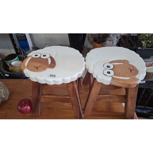 868 - Pair of sheep-themed wooden stools with painted tops. Approximately 11 inches high, 11 inches wide.