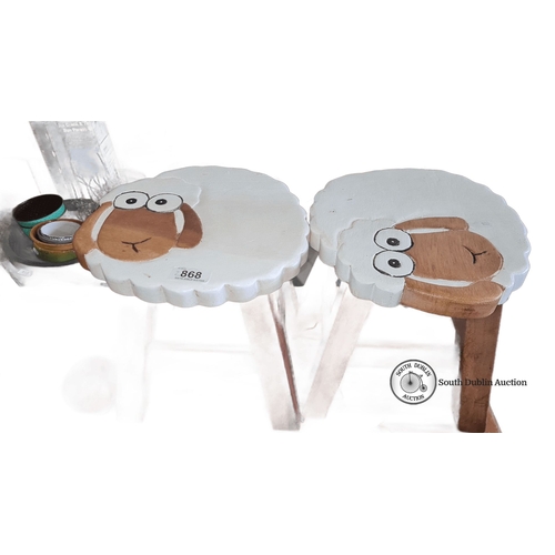 868 - Pair of sheep-themed wooden stools with painted tops. Approximately 11 inches high, 11 inches wide.