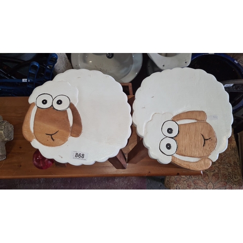 868 - Pair of sheep-themed wooden stools with painted tops. Approximately 11 inches high, 11 inches wide.