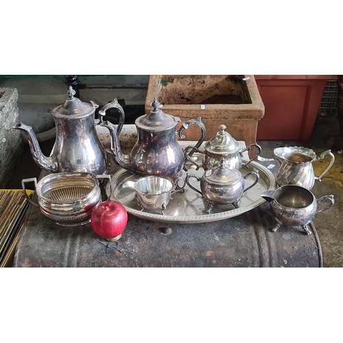 876 - Silver-plated tea and coffee service set includes a teapot, coffee pot, sugar bowl, creamer, waste b... 