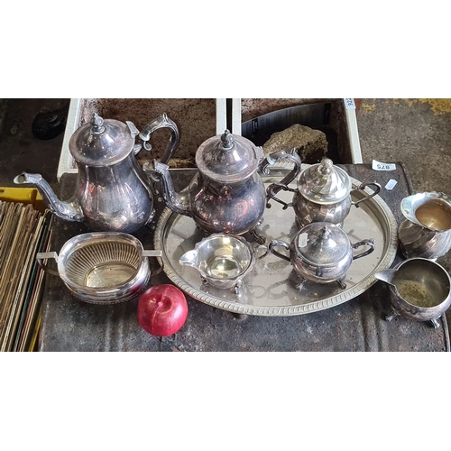 876 - Silver-plated tea and coffee service set includes a teapot, coffee pot, sugar bowl, creamer, waste b... 