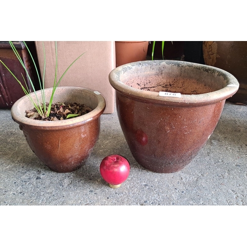 878 - Set of two brown terracotta planters, one with foliage. Rustic finish. Approximately 10 inches and 8... 