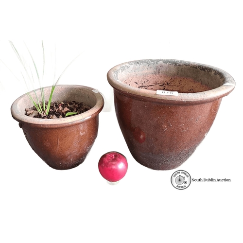 878 - Set of two brown terracotta planters, one with foliage. Rustic finish. Approximately 10 inches and 8... 