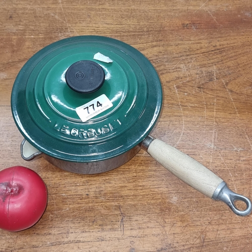 774 - A Le Creuset lidded saucepan with wooden handle. In very good condition.