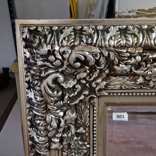 903 - Rectangular mirror with an intricately carved silver-gilt frame. Approximately 120 cm x 95 cm.