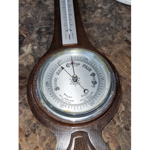 911 - Antique British barometer featuring carved oak design, thermometer, and barometric dial. 