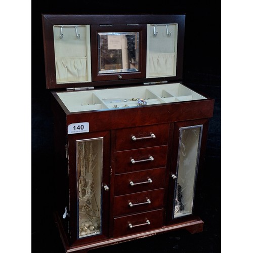 140 - A splendid wooden jewelry box featuring two glass fronted compartments to each side for storing neck... 