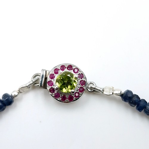 503 - Star Lot : A graduated sapphire necklace set with ruby & peridot silver clasp. Length - 42 cms. Weig... 