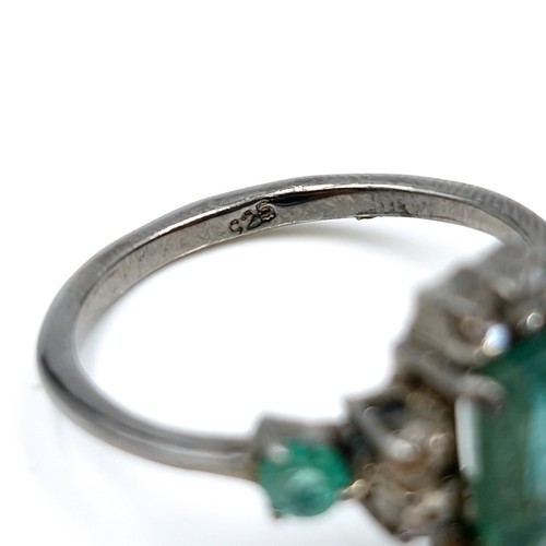 520 - Star Lot : A very pretty  three emerald and eight diamond ring mounted in sterling silver. Size - P.... 