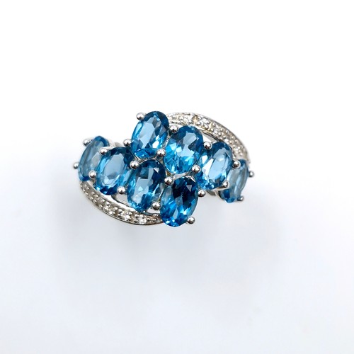 554 - A twin twist eight stone blue topaz ring set in sterling silver with TGGC stamped to band (The Genui... 