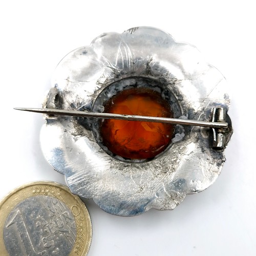 556 - A vintage Scottish silver agate stone brooch with a citrine central mount. Diameter - 4.5 cms. Weigh... 