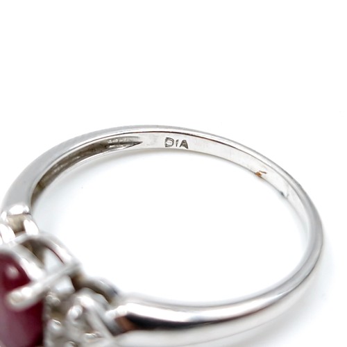 592 - Star lot : A nine carat white gold ruby and diamond ring. Diamond stamped to band. Ring size - P. We... 