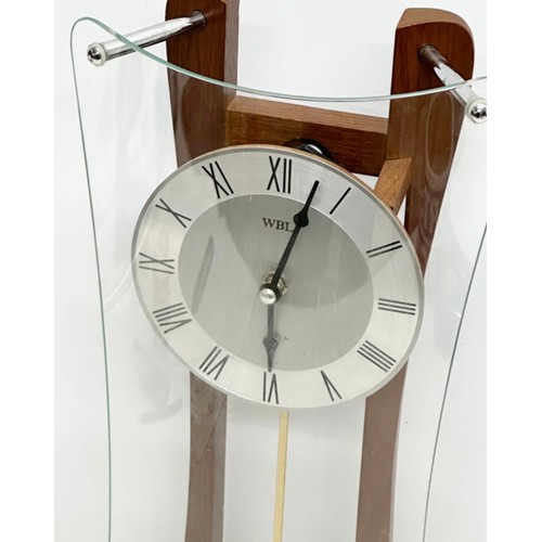 1123 - Wall clock featuring a wooden frame with curved glass design, central metal clock face, and Roman nu... 