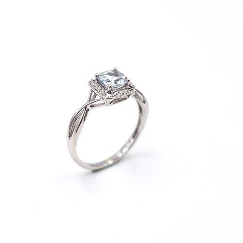 12 - Star lot : A lovely nine carat white gold aquamarine gemstone ring set diamonds  with a twist mount.... 