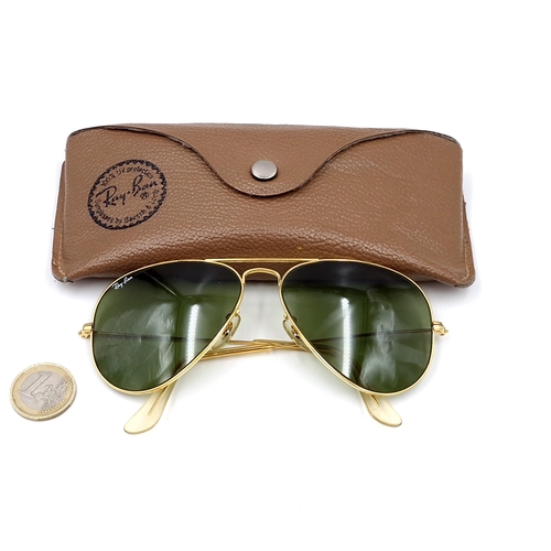 16 - A pair of Ray-Ban gold framed aviator style sunglasses. Lenses clear. Comes in original case.