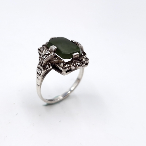 409 - A vintage jade stone ring set with marcasite detailing. Size - N. Weight - 5.64 grams.