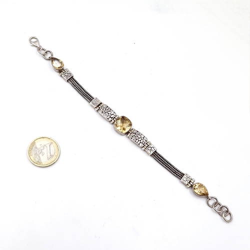 414 - A beautiful example of an antique sterling silver bracelet with three mounted citrine gemstones with... 