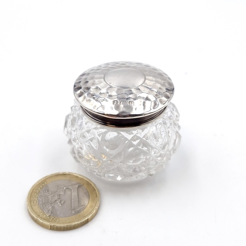 418 - A pretty hammered silver topped hon nail cut glass jar hallmarked Birmingham. Weight of lid - 3.75 g... 