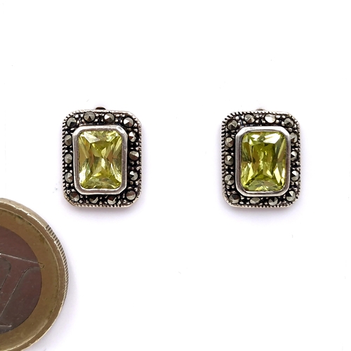 499 - A pair of sterling silver peridot stud earrings with marcasite detailing. Total weight - 4.4 grams. ... 