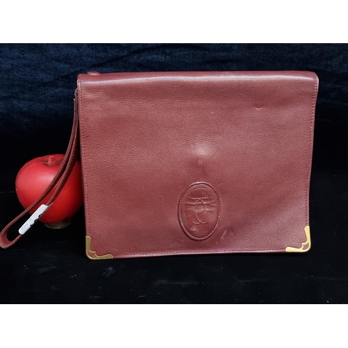 163 - Star Lot: An original vintage Cartier Paris Burgundy leather clutch bag with handwear. RRP: €280 on ... 