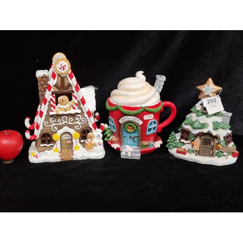 200 - Three Christmas fairy house decorations including a gingerbread man house, two houses in the form of... 