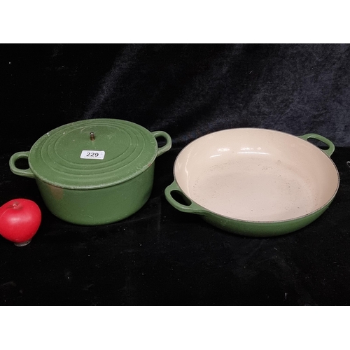 229 - Two heavy cast iron pieces of Le Creuset kitchenware including a lidded casserole dish and a double ... 