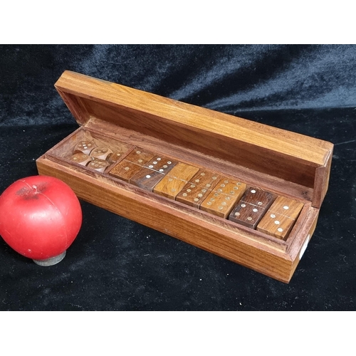 231 - A vintage dominos set housed in a camphor wood box which features brass toned decoration to top and ... 