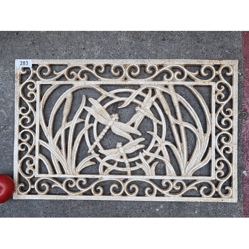 283 - A heavy cast metal boot door mat in the art nouveau style, with dragon fly designs.