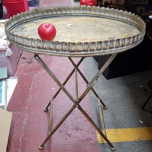 648 - Antique brass folding tray table with scalloped edge detail. Approximately 25 inches tall by 18 inch... 