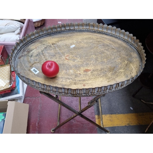 648 - Antique brass folding tray table with scalloped edge detail. Approximately 25 inches tall by 18 inch... 