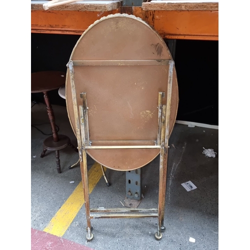 648 - Antique brass folding tray table with scalloped edge detail. Approximately 25 inches tall by 18 inch... 