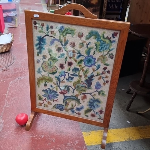 649 - Antique oak firescreen with floral needlepoint, approximately 60cm x 80cm. Front features vibrant ta... 