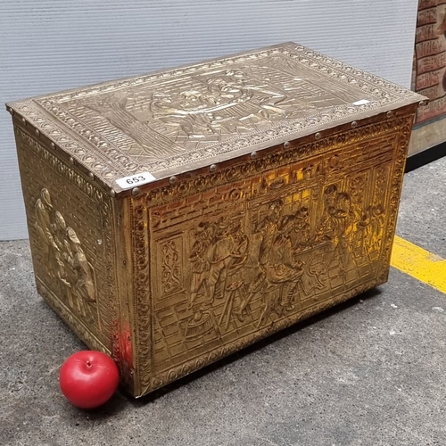 653 - Brass embossed storage chest with intricate figurative scenes and a hinged lid. Approximately 24